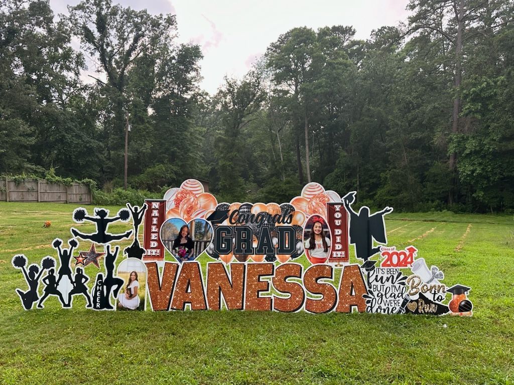 A yard sign for vanessa is sitting in the middle of a grassy field.