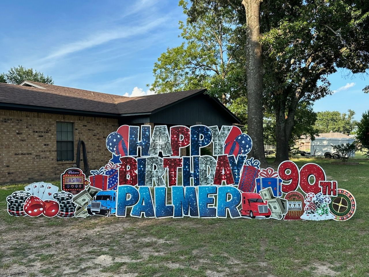 A large happy birthday sign is in front of a house.