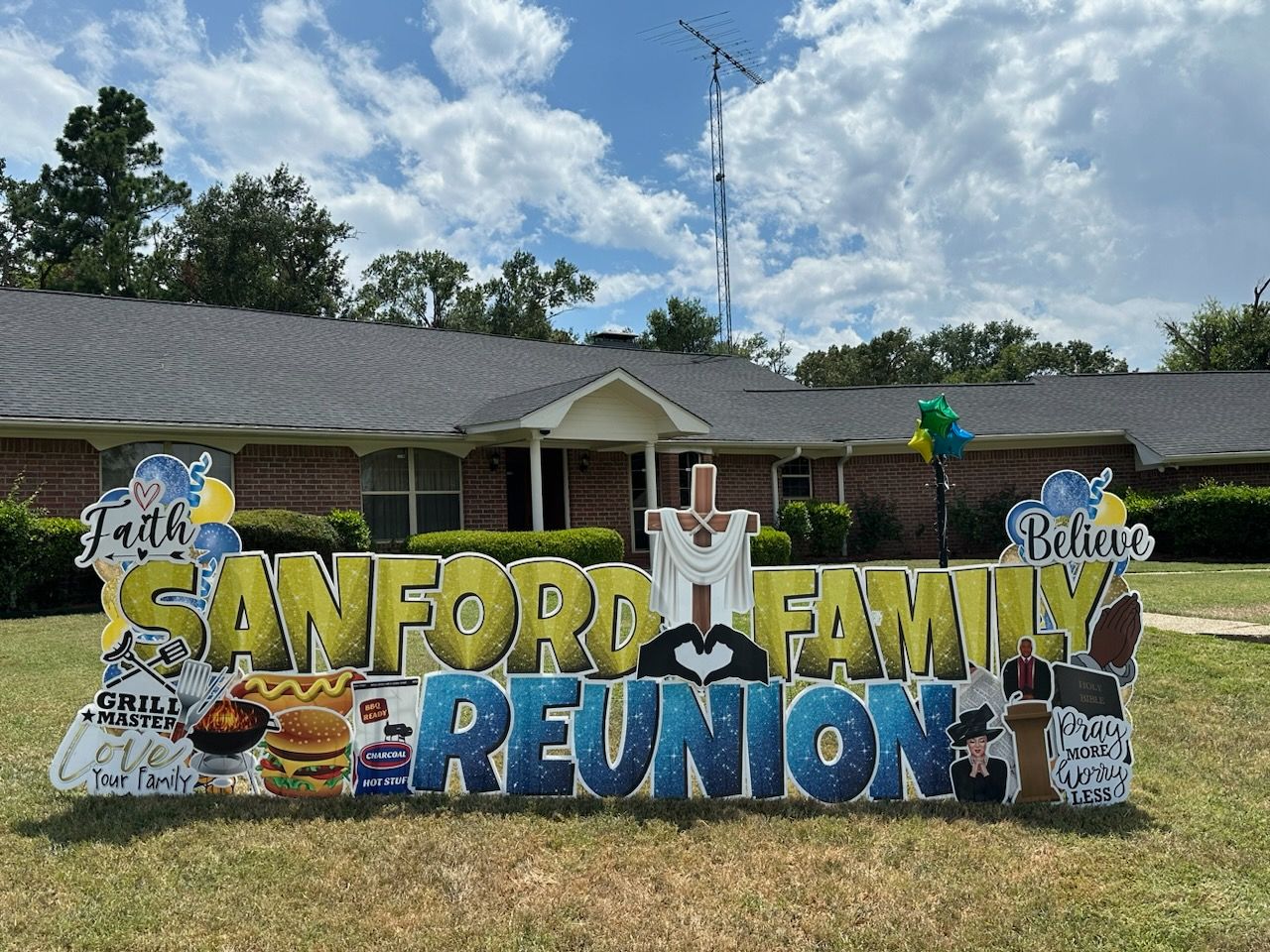 A yard sign for a family reunion is in front of a house.