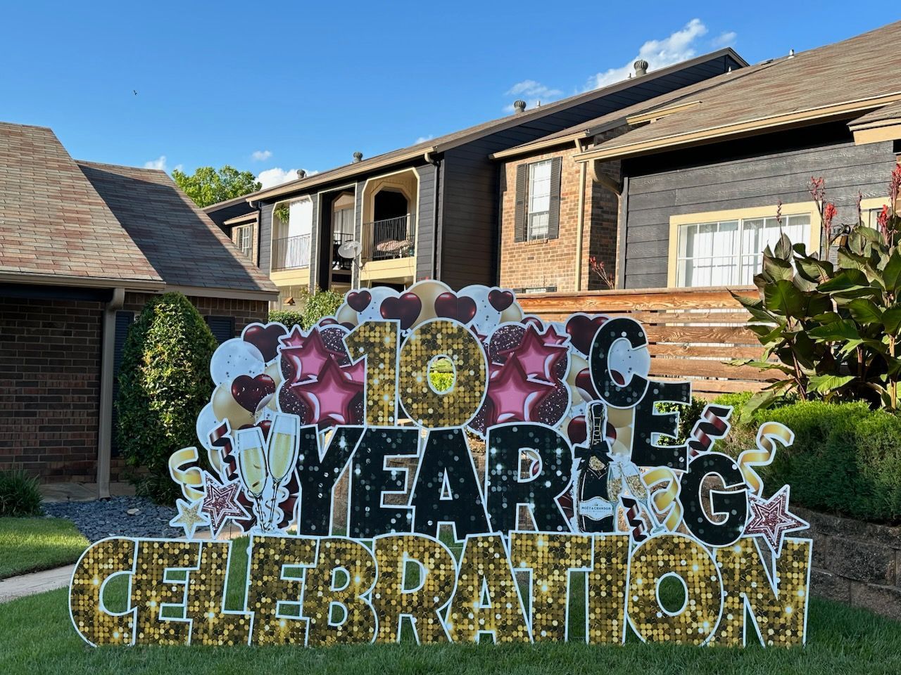 A yard sign for a 10th anniversary celebration is in front of a house.