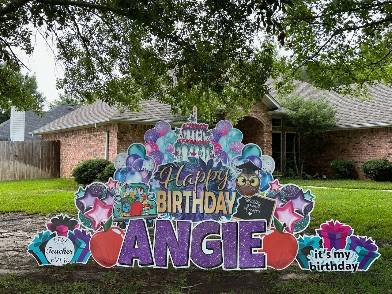 A happy birthday sign is in front of a house.