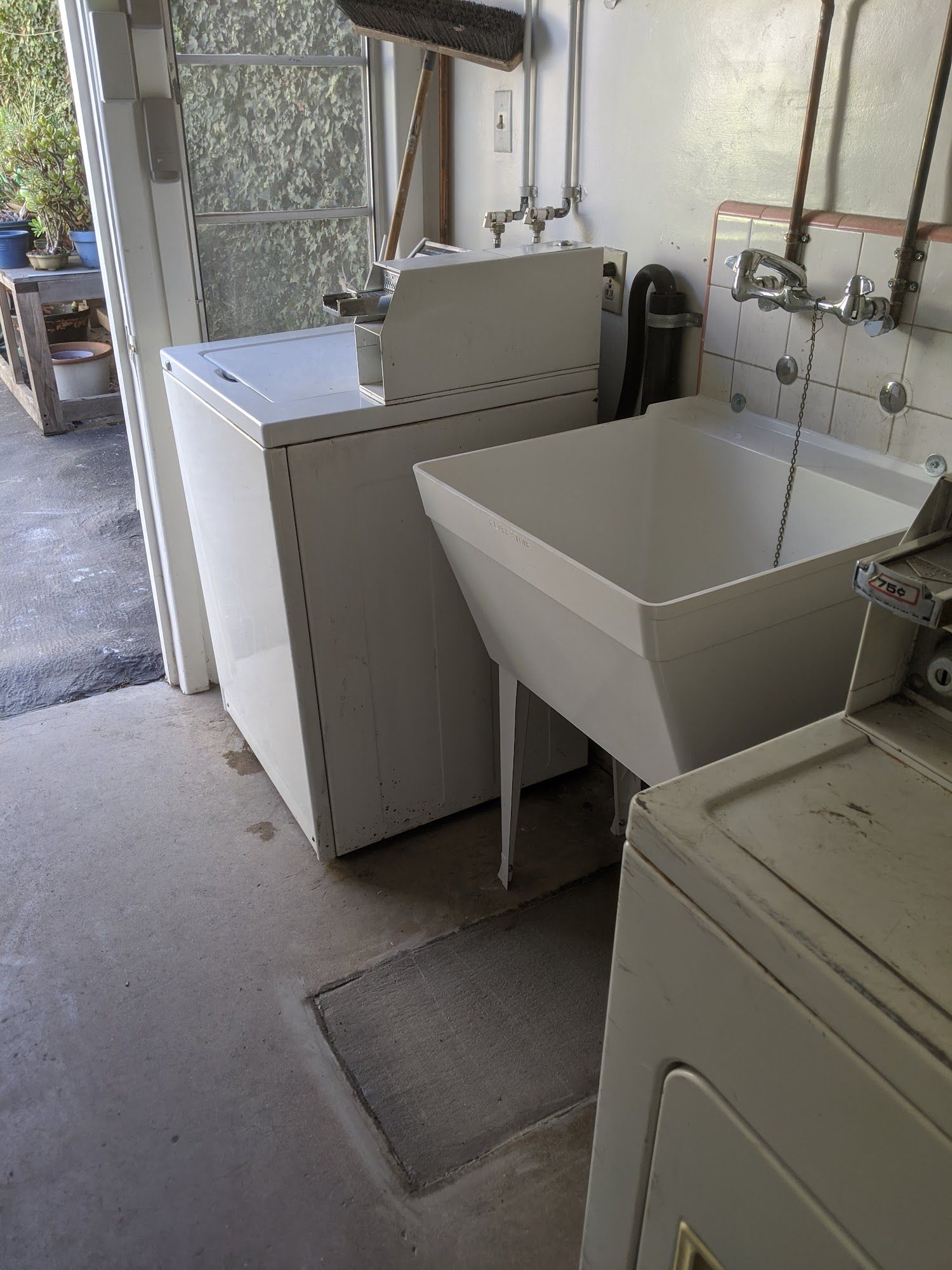 Laundry room with white washer, utility sink, and a front-load dryer.