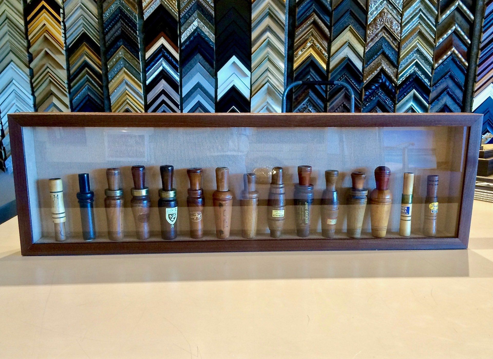 A display case filled with duck calls is sitting on a table.