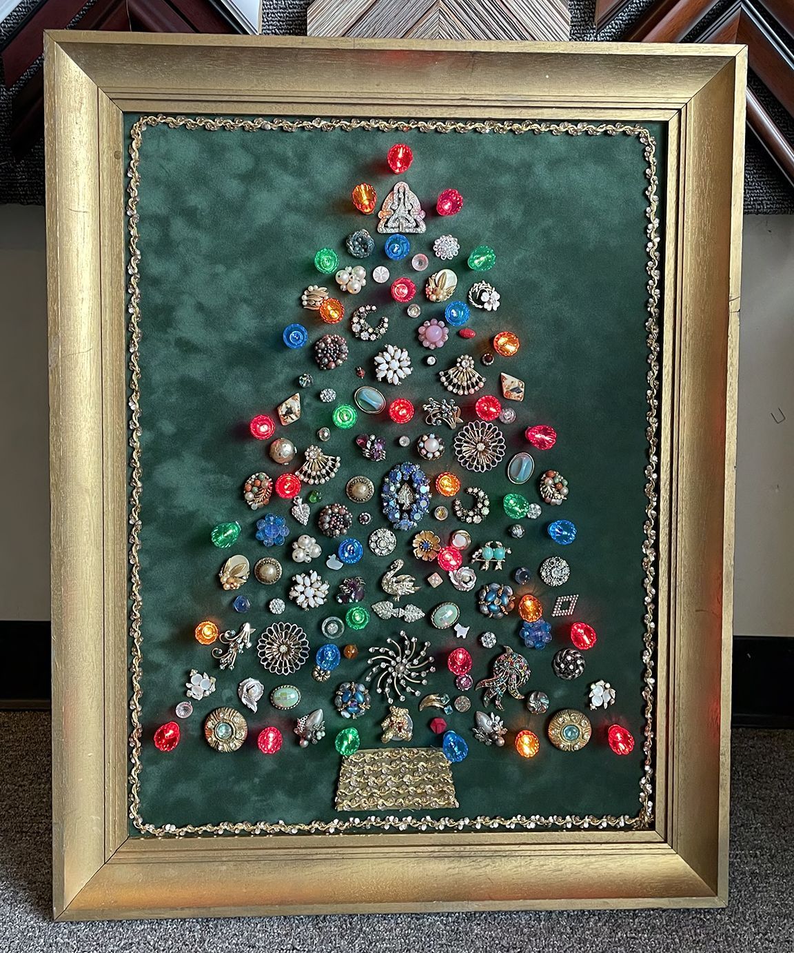 A framed picture of a christmas tree made of buttons