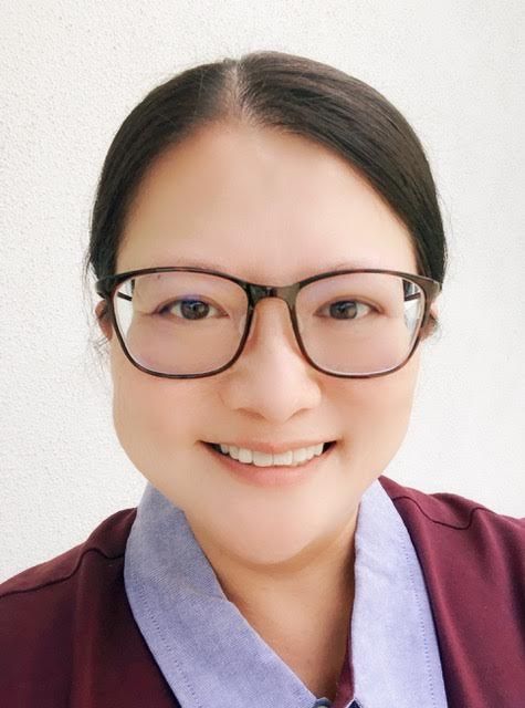 A woman wearing glasses is smiling for the camera