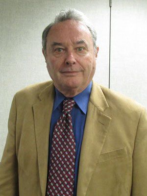 A man in a suit and tie is smiling for the camera