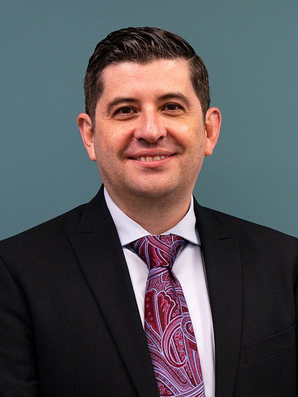 A man in a suit and tie is smiling for the camera.