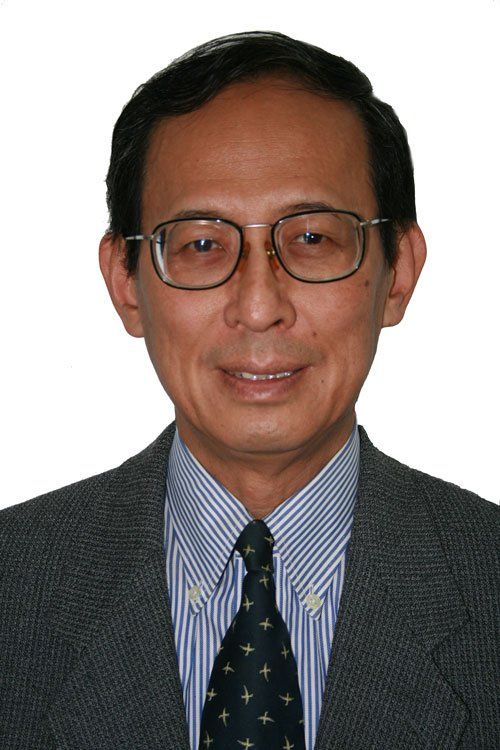 A man in a suit and tie is smiling for the camera