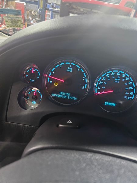 A close up of the dashboard of a car with a warning light on