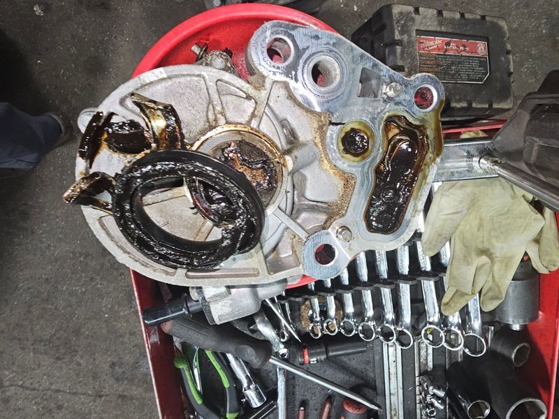 A red bucket filled with tools and a piece of metal