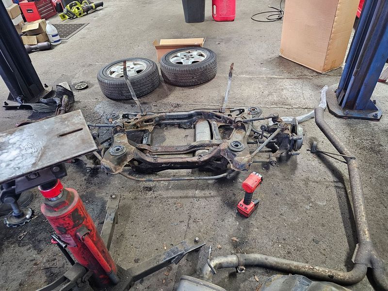A car is sitting on a lift in a garage.