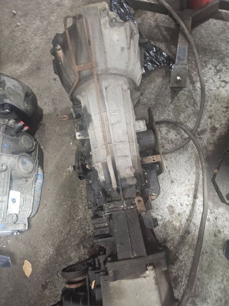 A gearbox is sitting on the ground next to a vacuum cleaner.