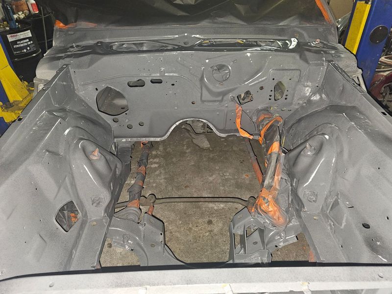 A car is sitting on a lift in a garage.