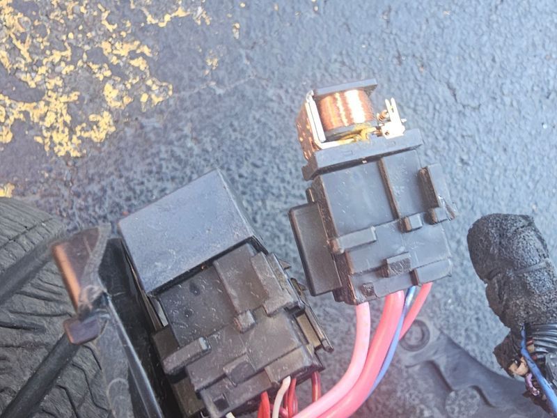 A close up of a fuse box with wires coming out of it.
