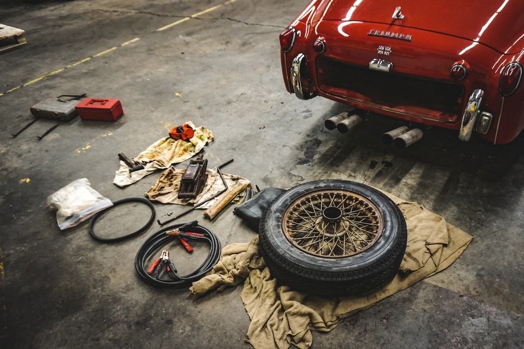 A red car is being worked on in a garage.