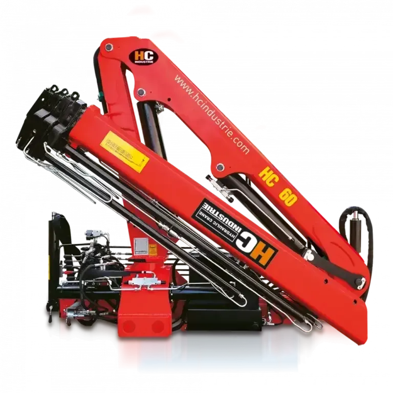 A crane lifting a rectangular building module against a blue sky.