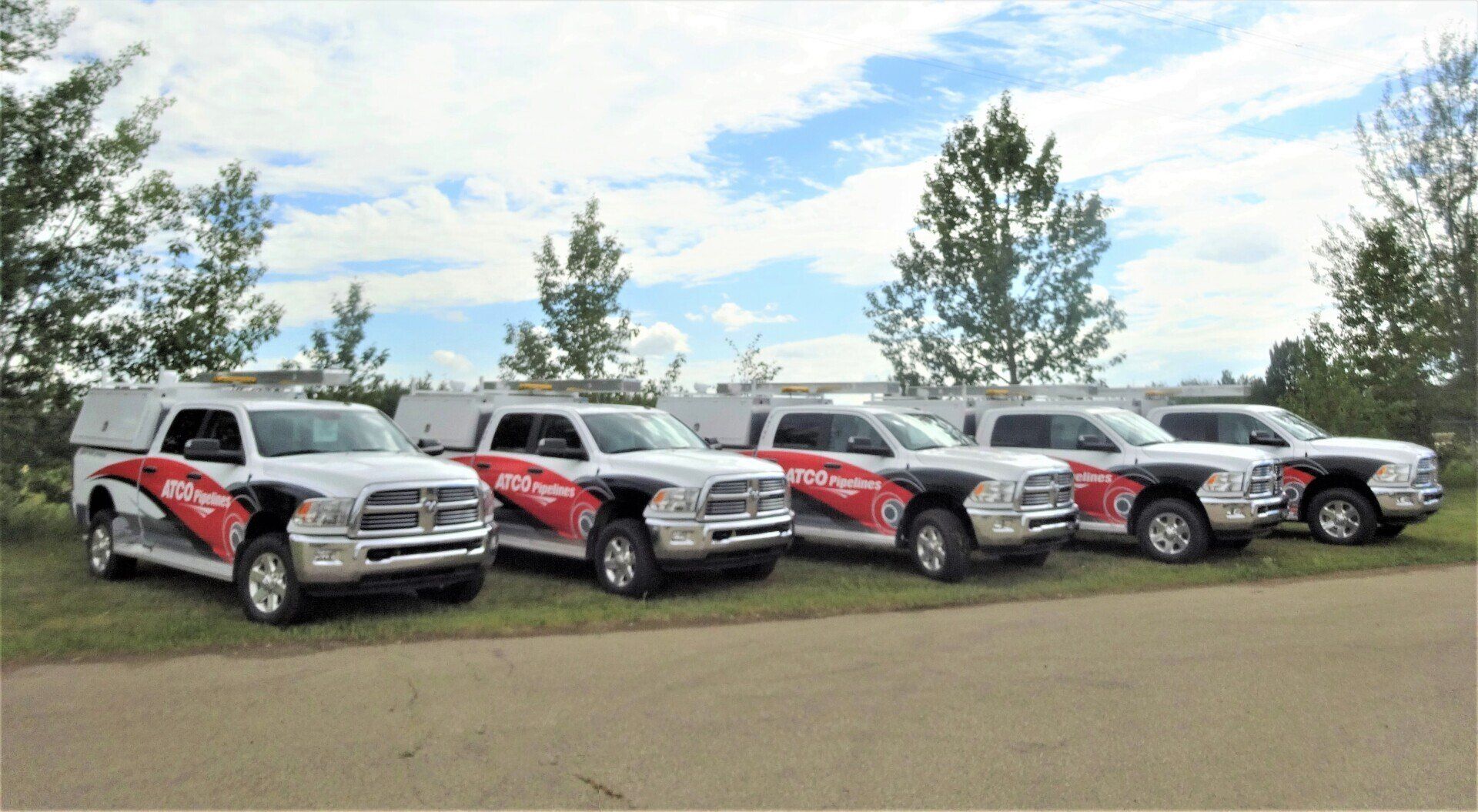 A row of trucks parked next to each other on the side of the road.