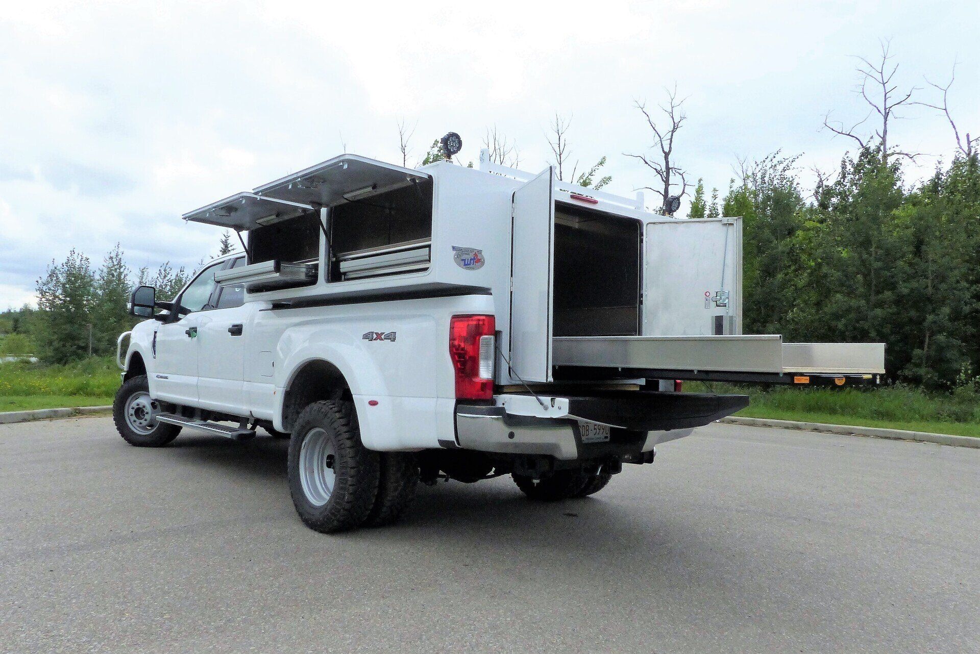 A white truck with a canopy on top of it is parked on the side of the road.