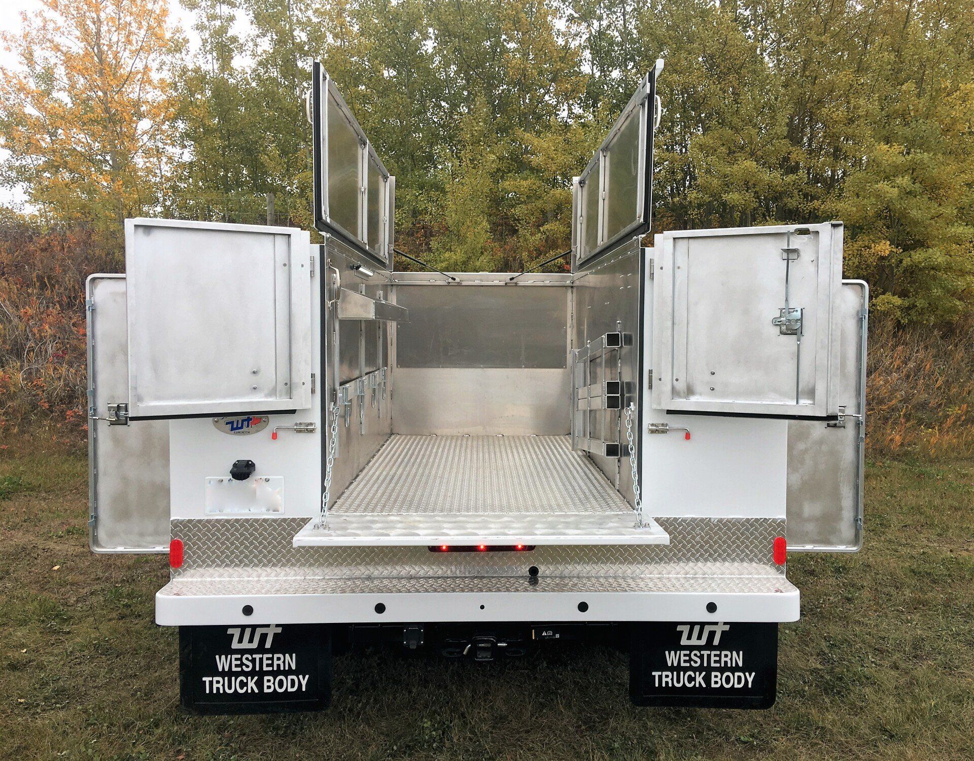 The back of a white truck with the doors open.