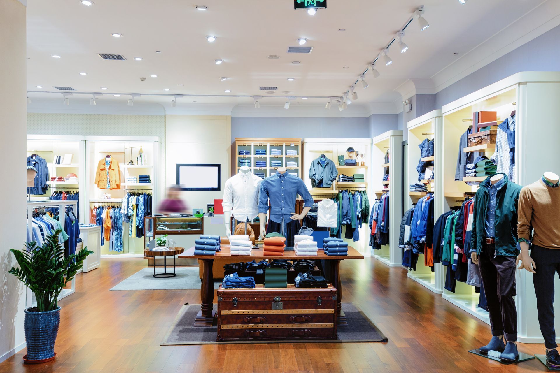 Bright clothing store interior with racks of jeans, sweaters, and folded shirts on display