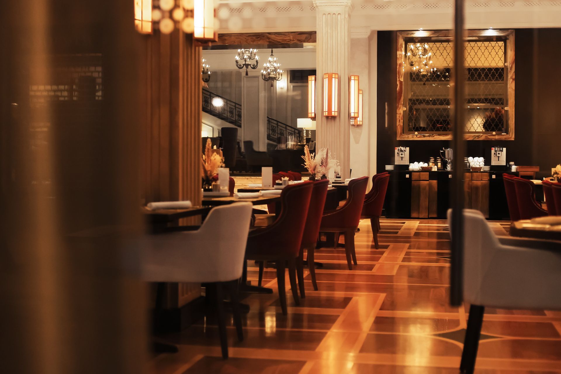 Elegant restaurant interior with warm lighting, polished floor, and neatly arranged tables and chairs