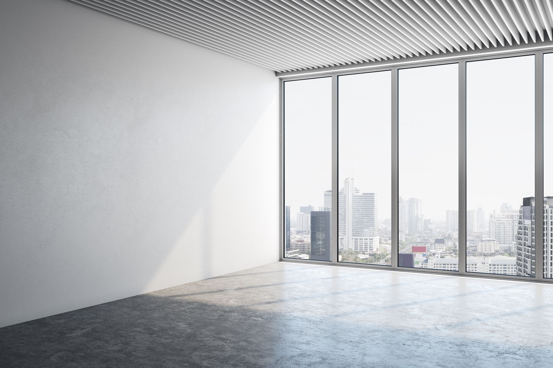Empty modern room with large floor-to-ceiling windows and a city view Empty modern room with large floor-to-ceiling windows and a city view