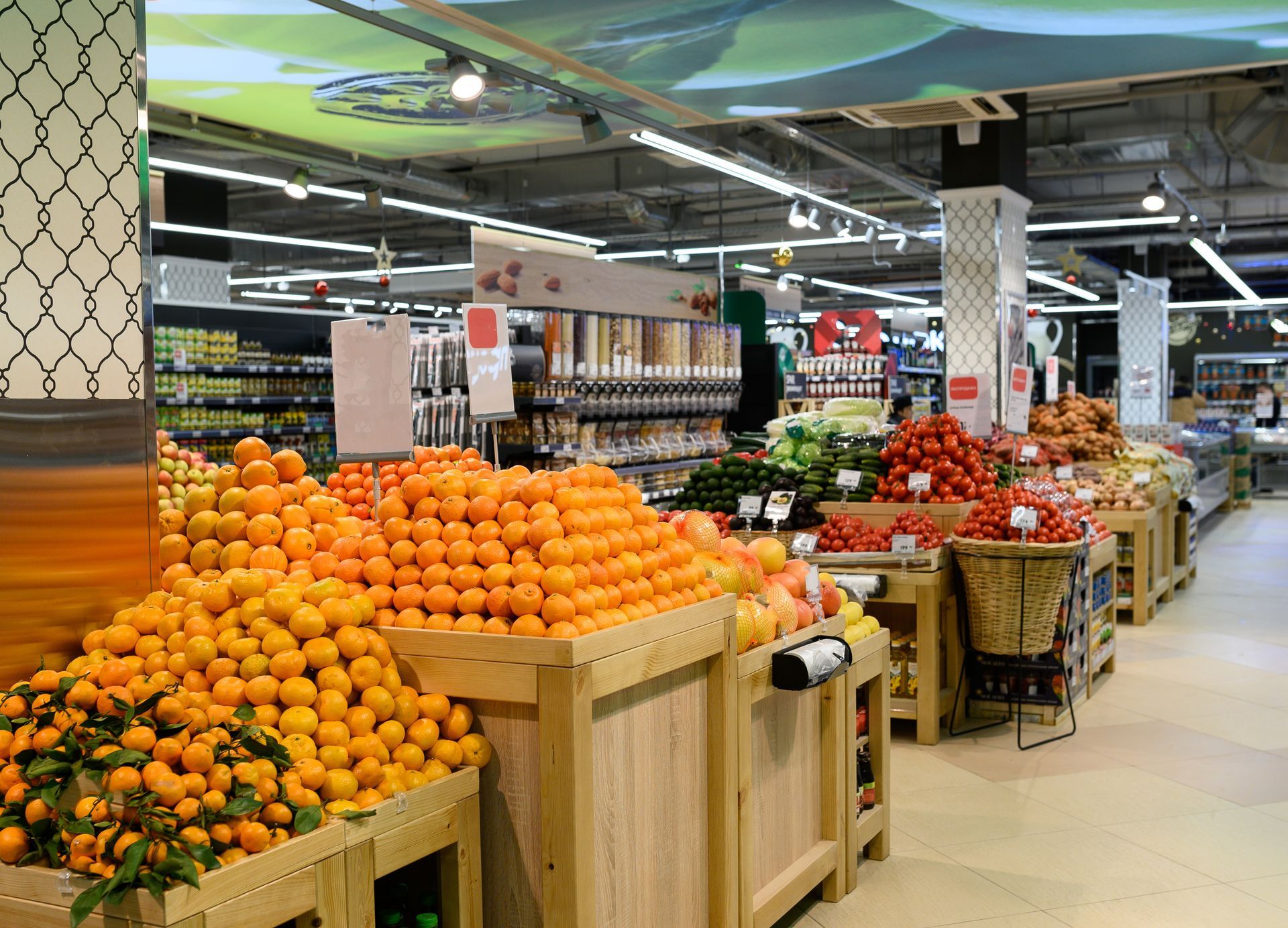 Produce aisle with stacked oranges and tomatoes in a grocery store Produce aisle with stacked oranges and tomatoes in a grocery store