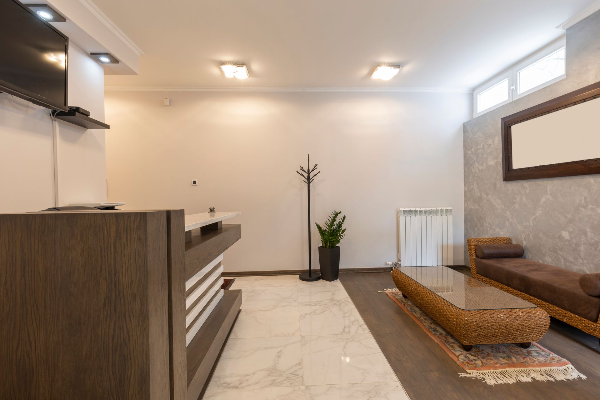 Modern minimalist spa room with wood lounge chairs, marble floor, and soft lighting