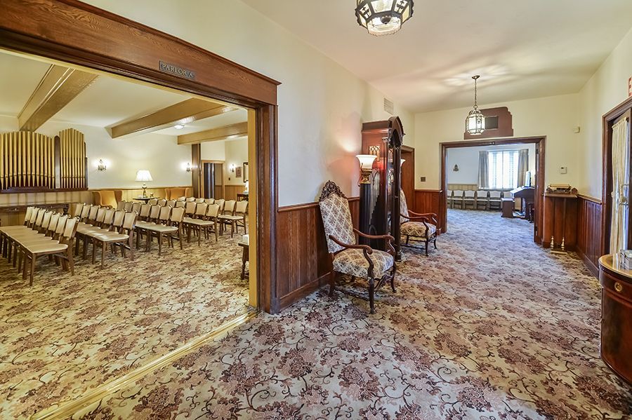 Interior of John F. Fluehr & Sons, Inc with chapel and lobby, ornate decor, carpet, and wooden accents.