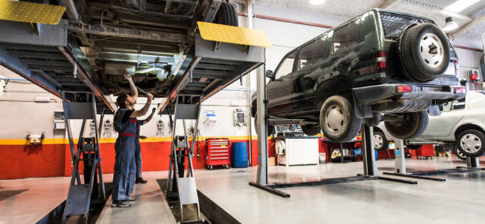A man is working on a car in a garage. | East Carolina Automotive