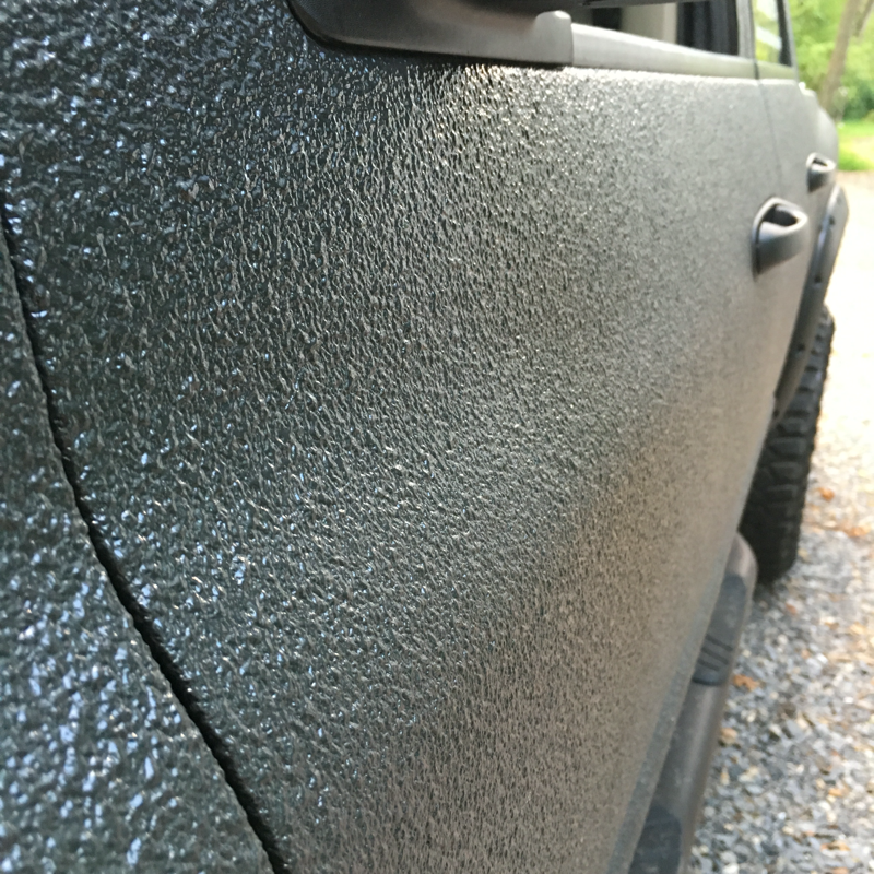 A close up of the side of a black truck