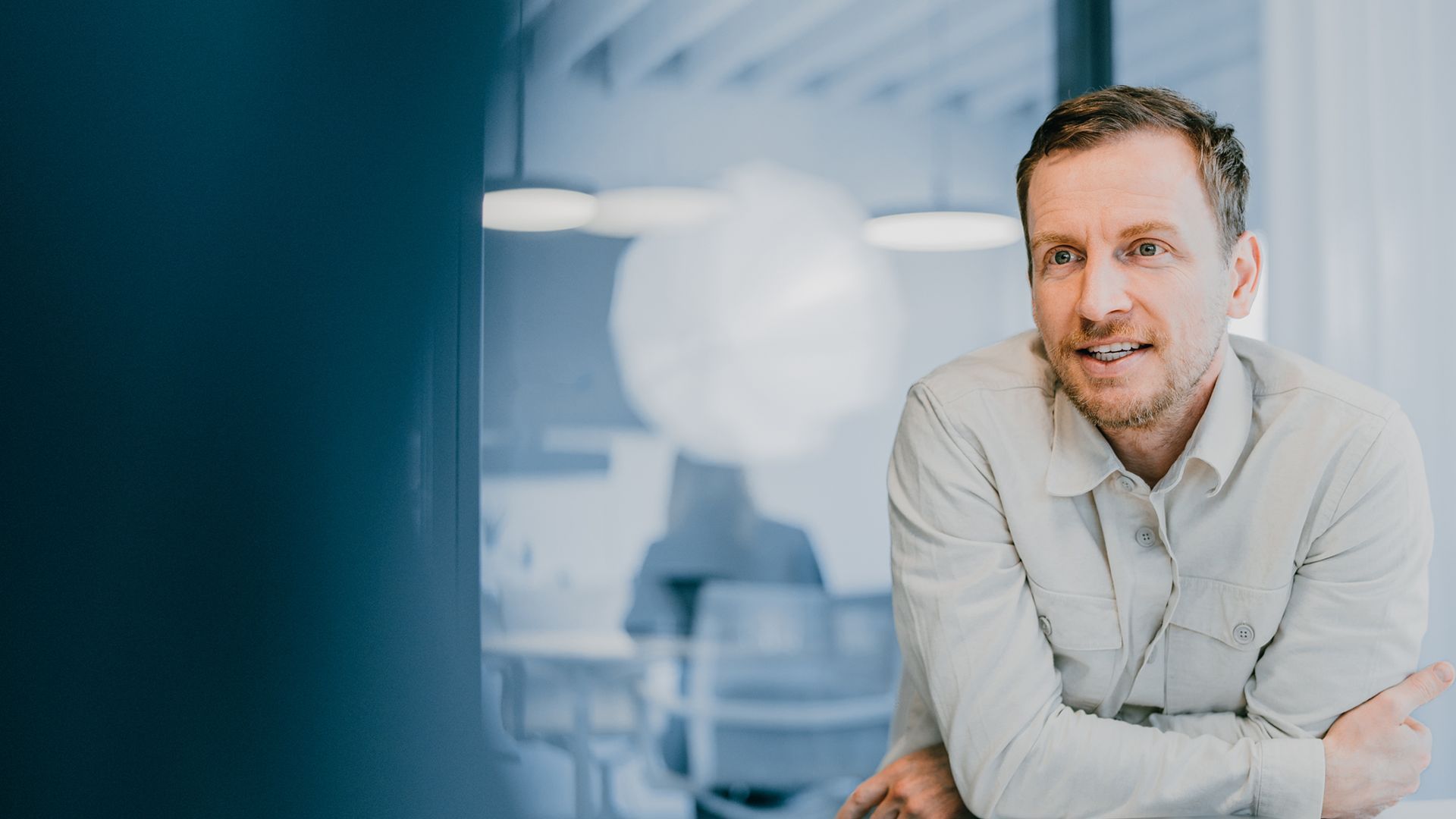 An zoi employee leaning on a desk