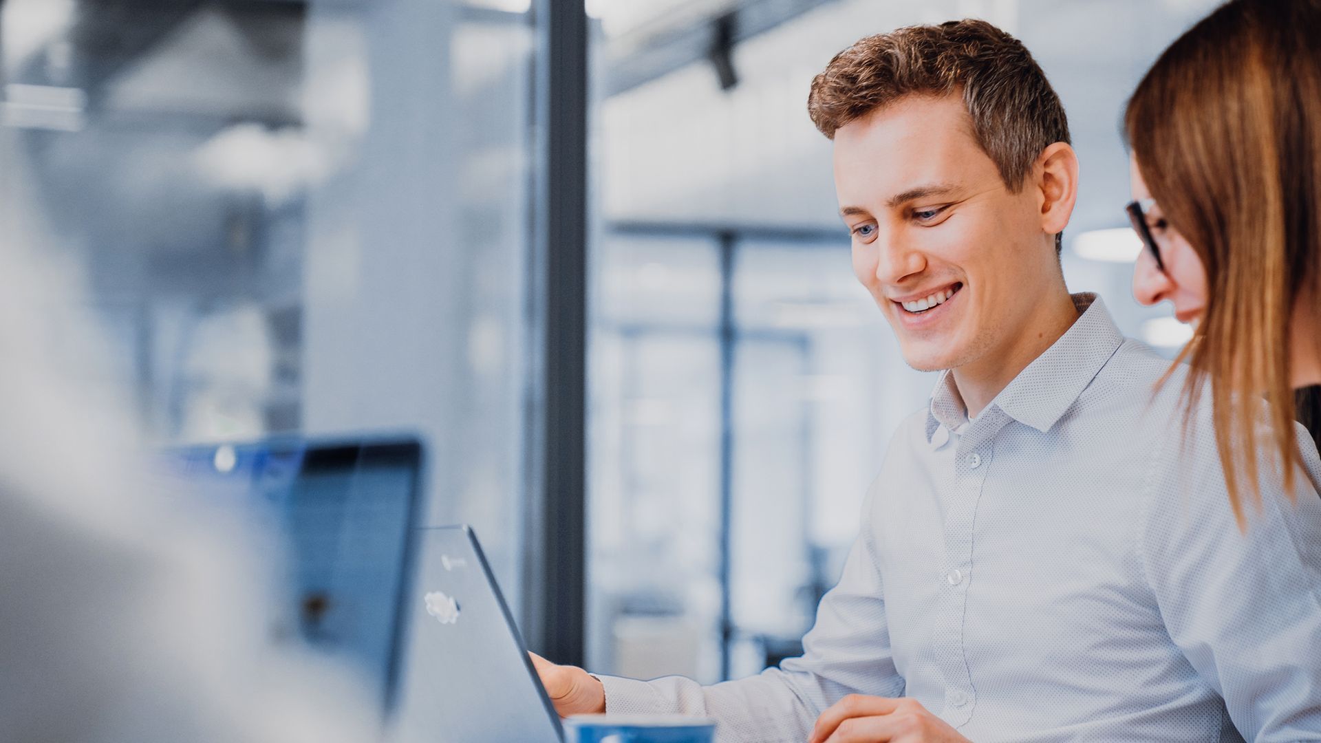 two zoi employees looking at their laptop