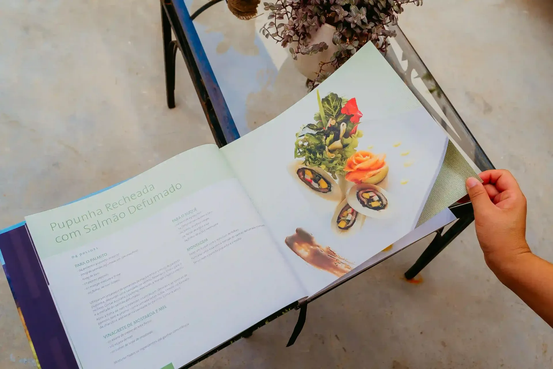 Uma pessoa está segurando um livro com uma imagem de comida.-Pousada-Recanto-do-Chef