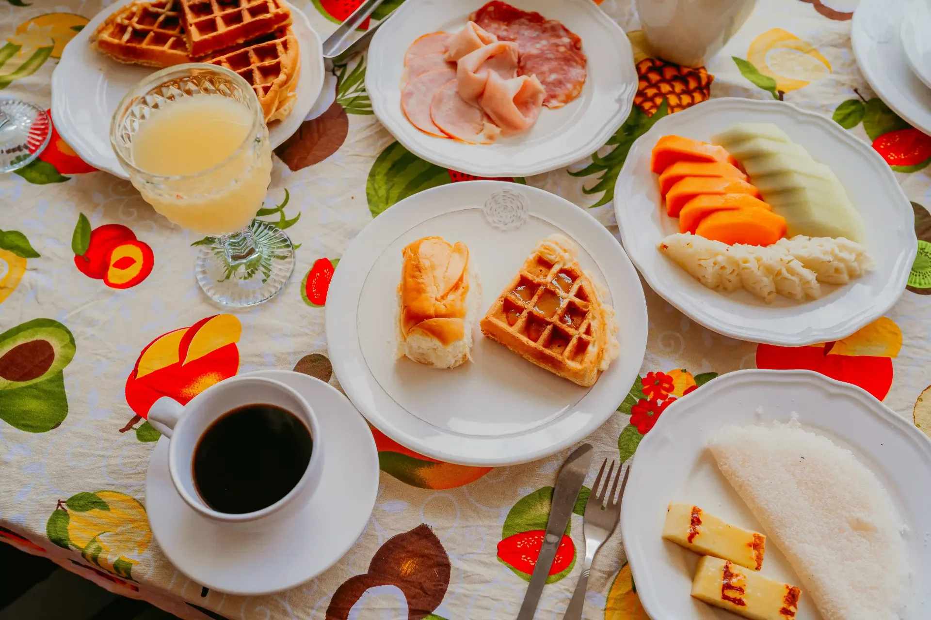 Uma mesa coberta com pratos de comida e uma xícara de café.-Pousada-Recanto-do-Chef