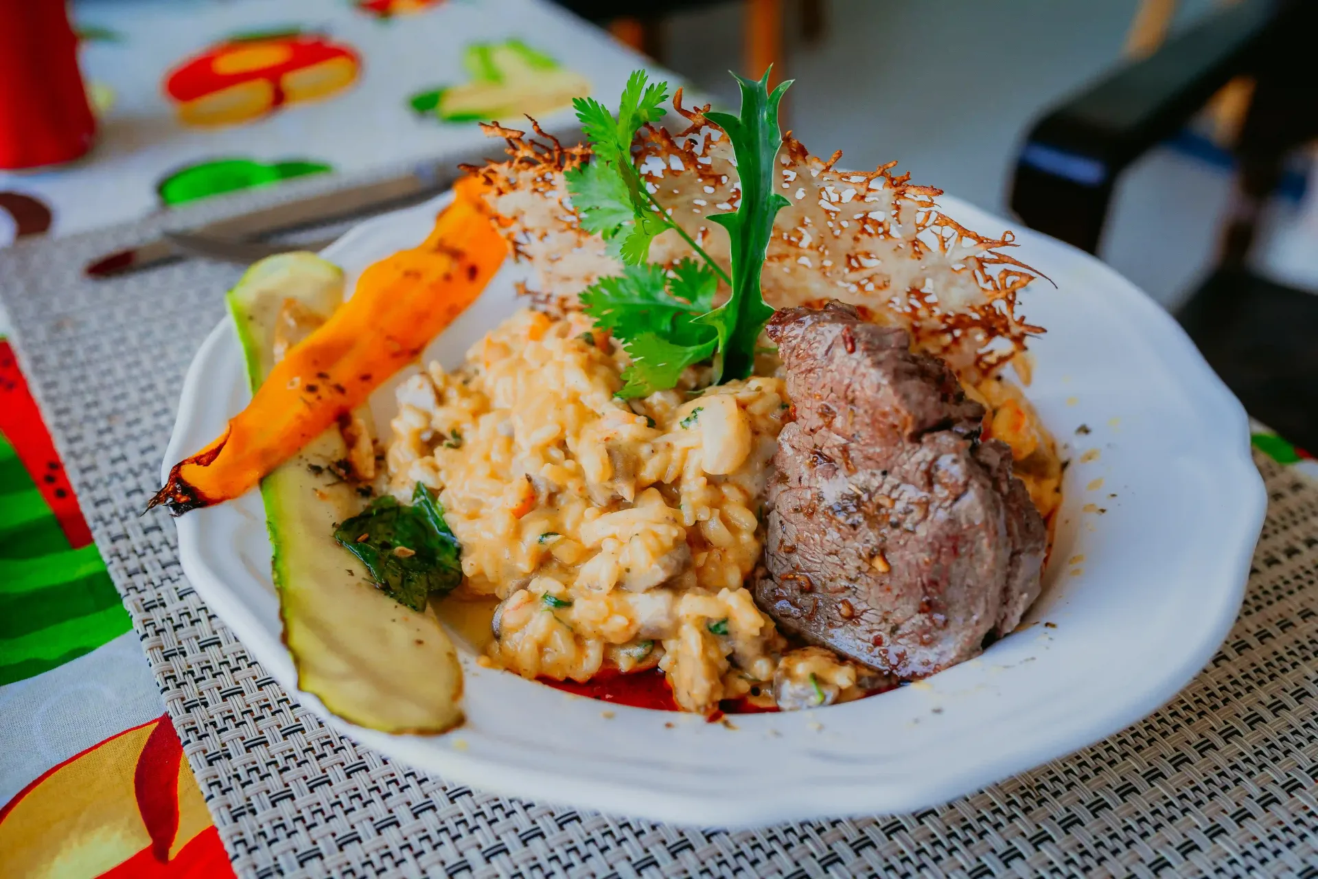Um prato de comida com carne e vegetais sobre uma mesa.-Pousada-Recanto-do-Chef