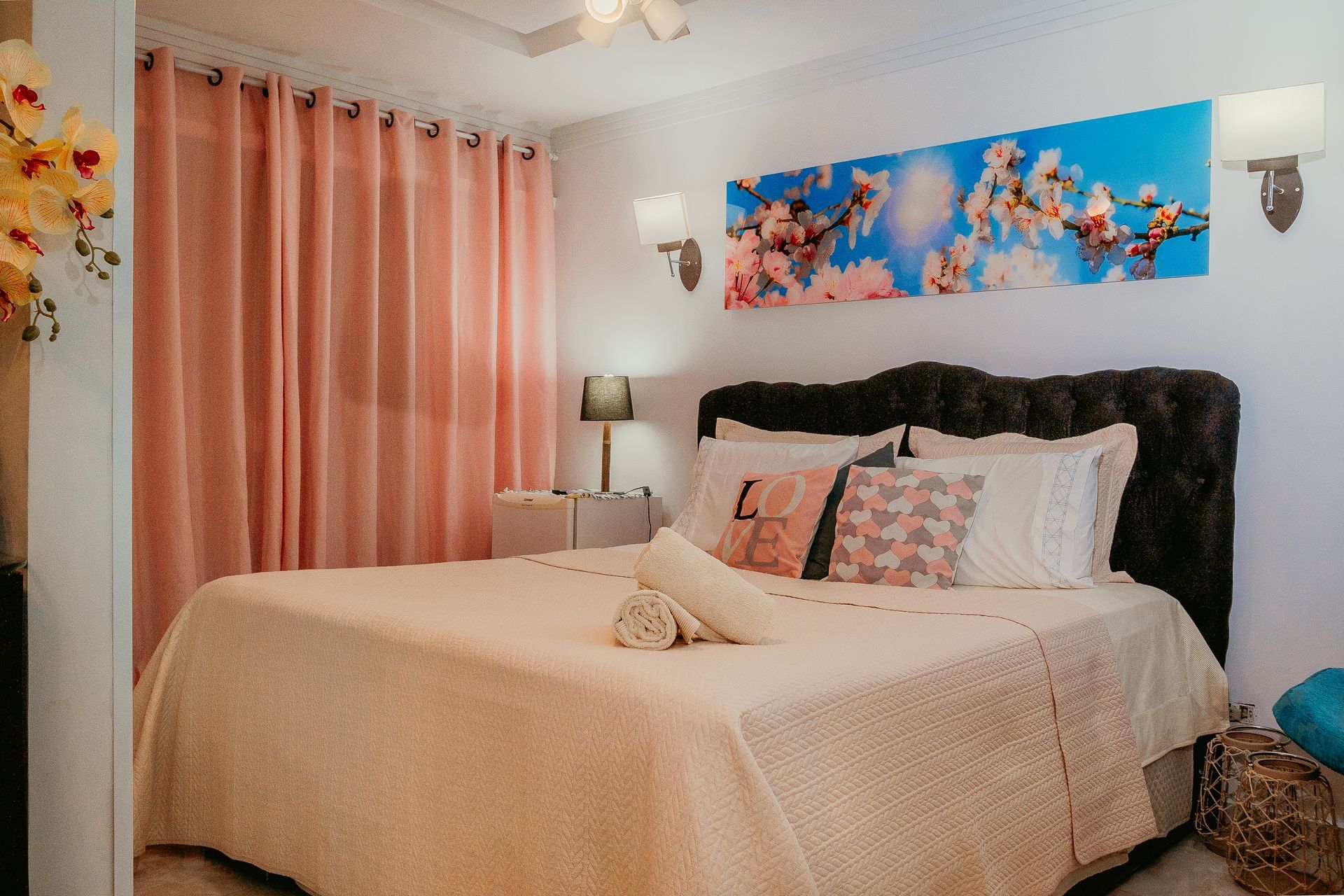 Um quarto com uma cama king size, cortinas rosa e uma pintura na parede.-Pousada-Recanto-do-Chef