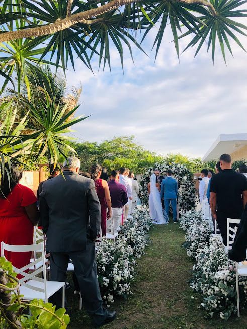 Uma noiva e um noivo estão caminhando pelo corredor em uma cerimônia de casamento.-Pousada-Recanto-do-Chef