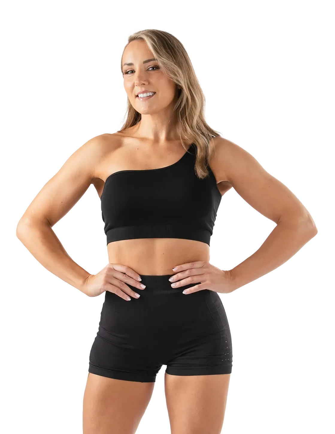 Maeve in black athletic wear, hands on hips, smiling.