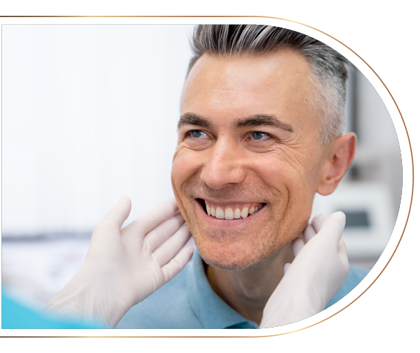 A man is smiling while getting his teeth examined by a dentist.