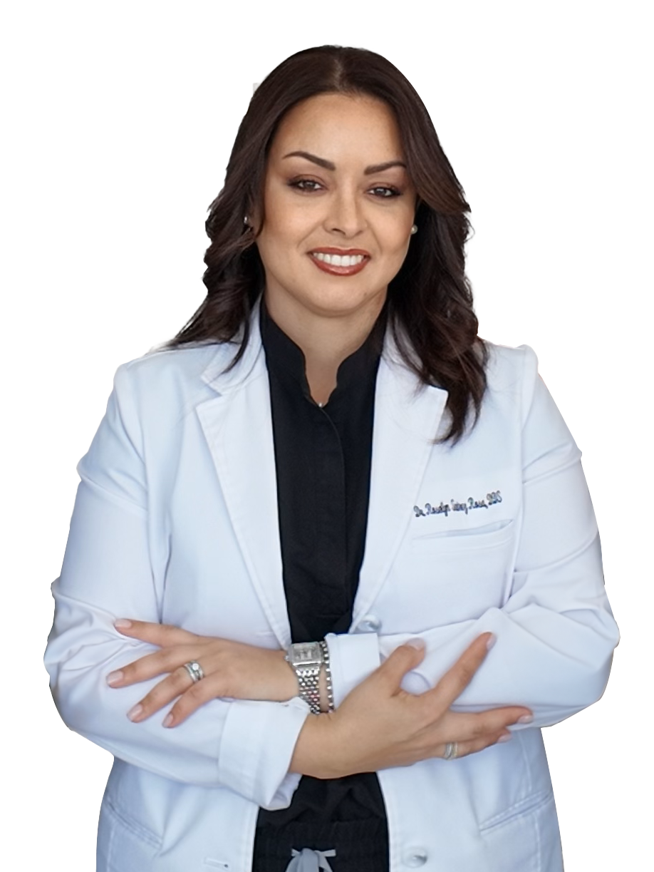 A woman in a white lab coat is smiling with her arms crossed