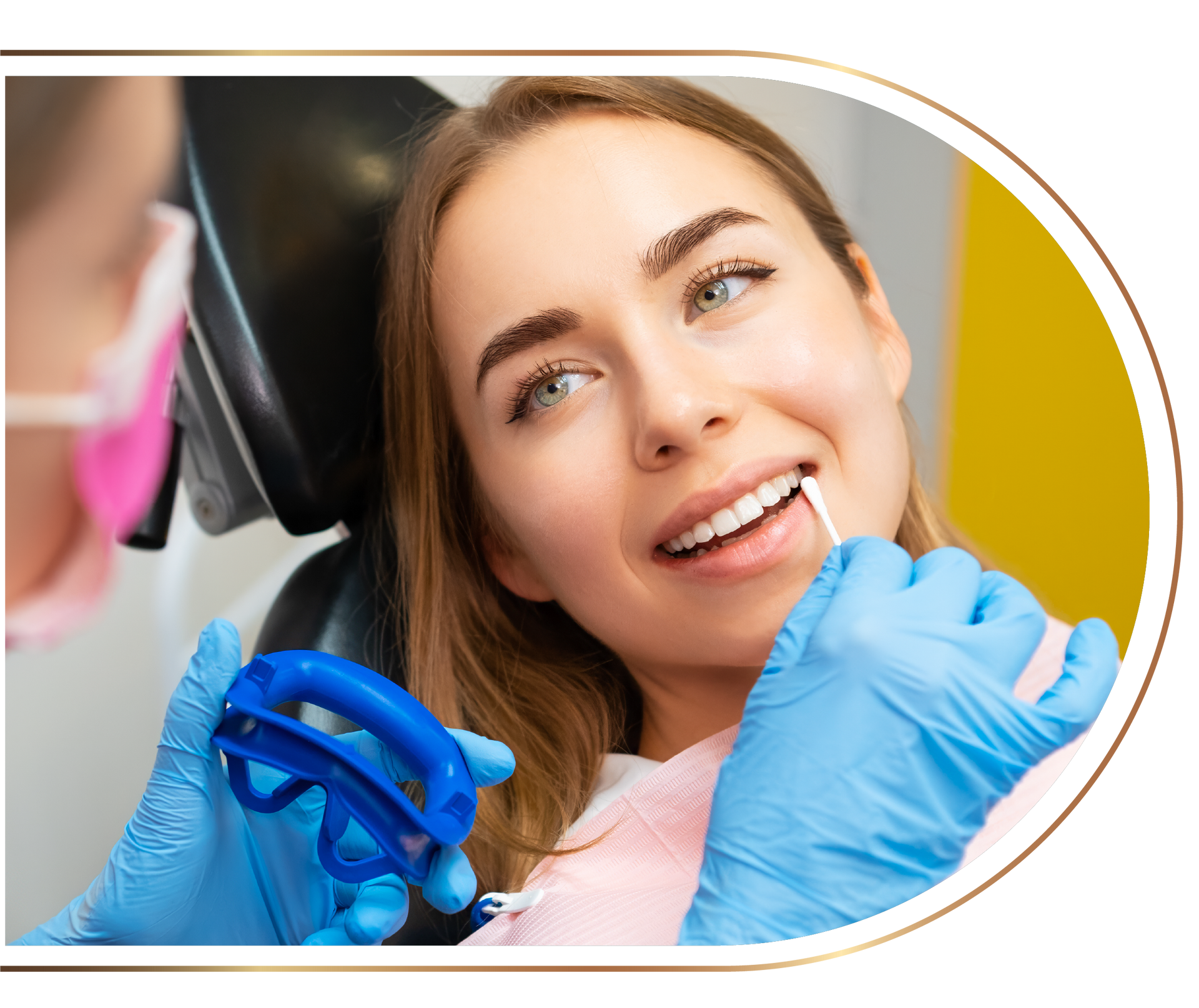 A woman is sitting in a dental chair while a dentist examines her teeth.