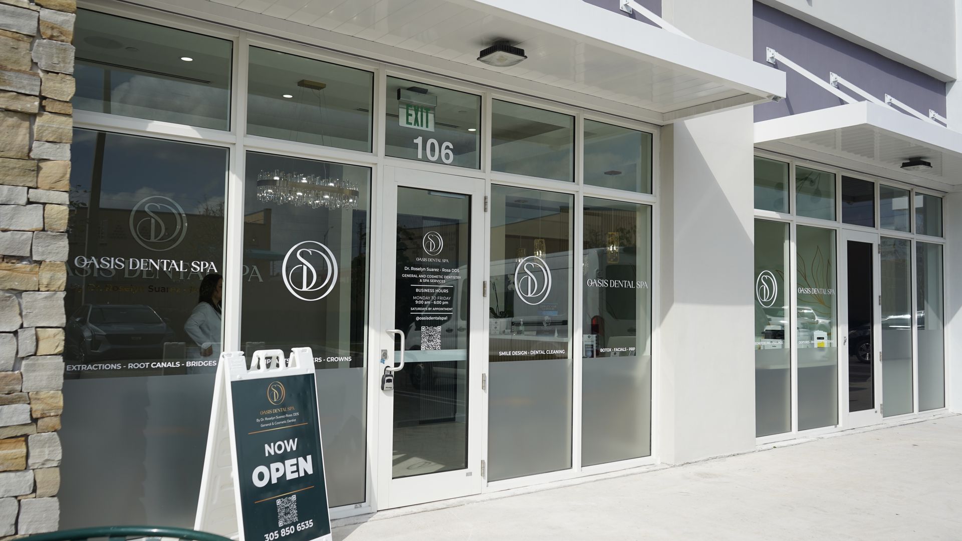 A store front with a sign that says `` now open '' in front of it.