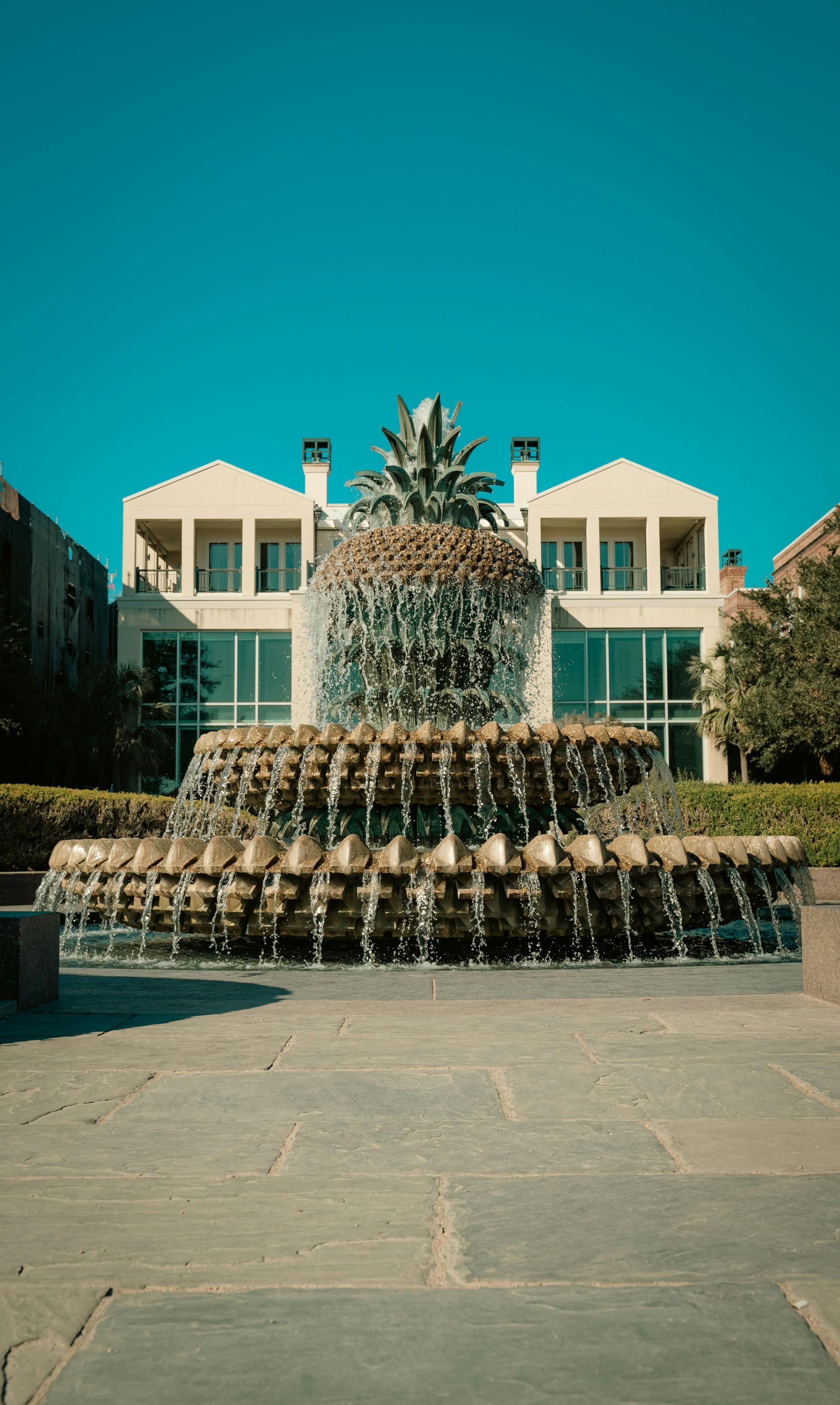 A woman is carrying a little girl on her shoulders in a field at sunset.
