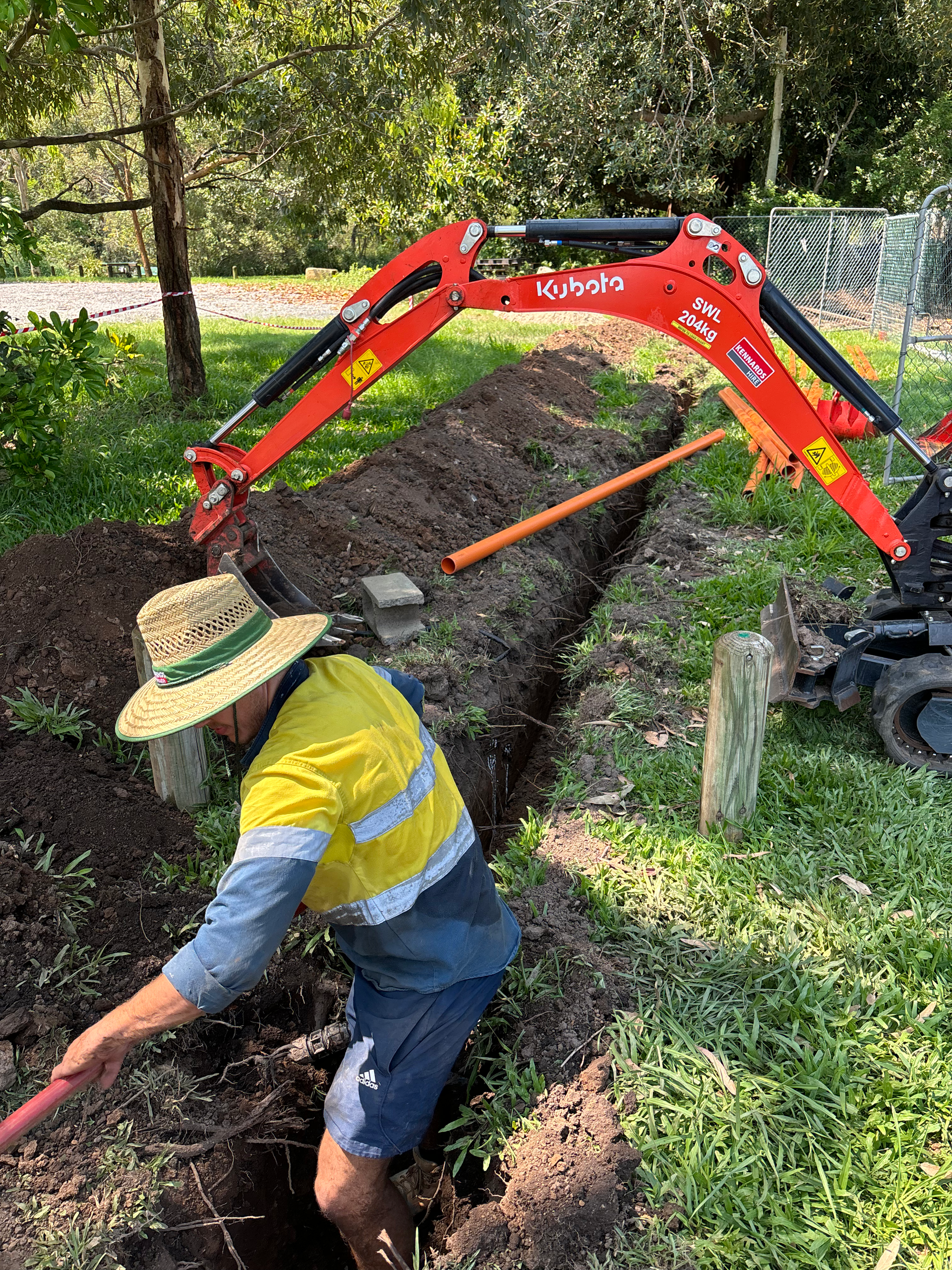 A man is digging a hole in the ground with a shovel.