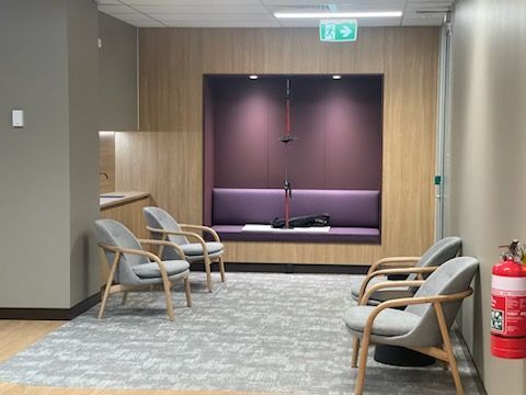 A waiting room with chairs and a fire extinguisher.