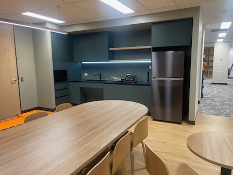 A kitchen with a table and chairs and a refrigerator.