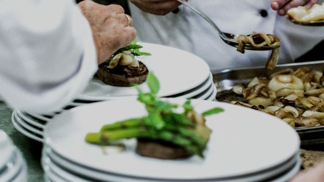A group of chefs are preparing food in a kitchen.