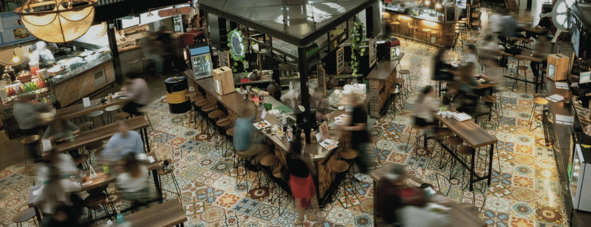 A group of people are sitting at tables in a cafeteria