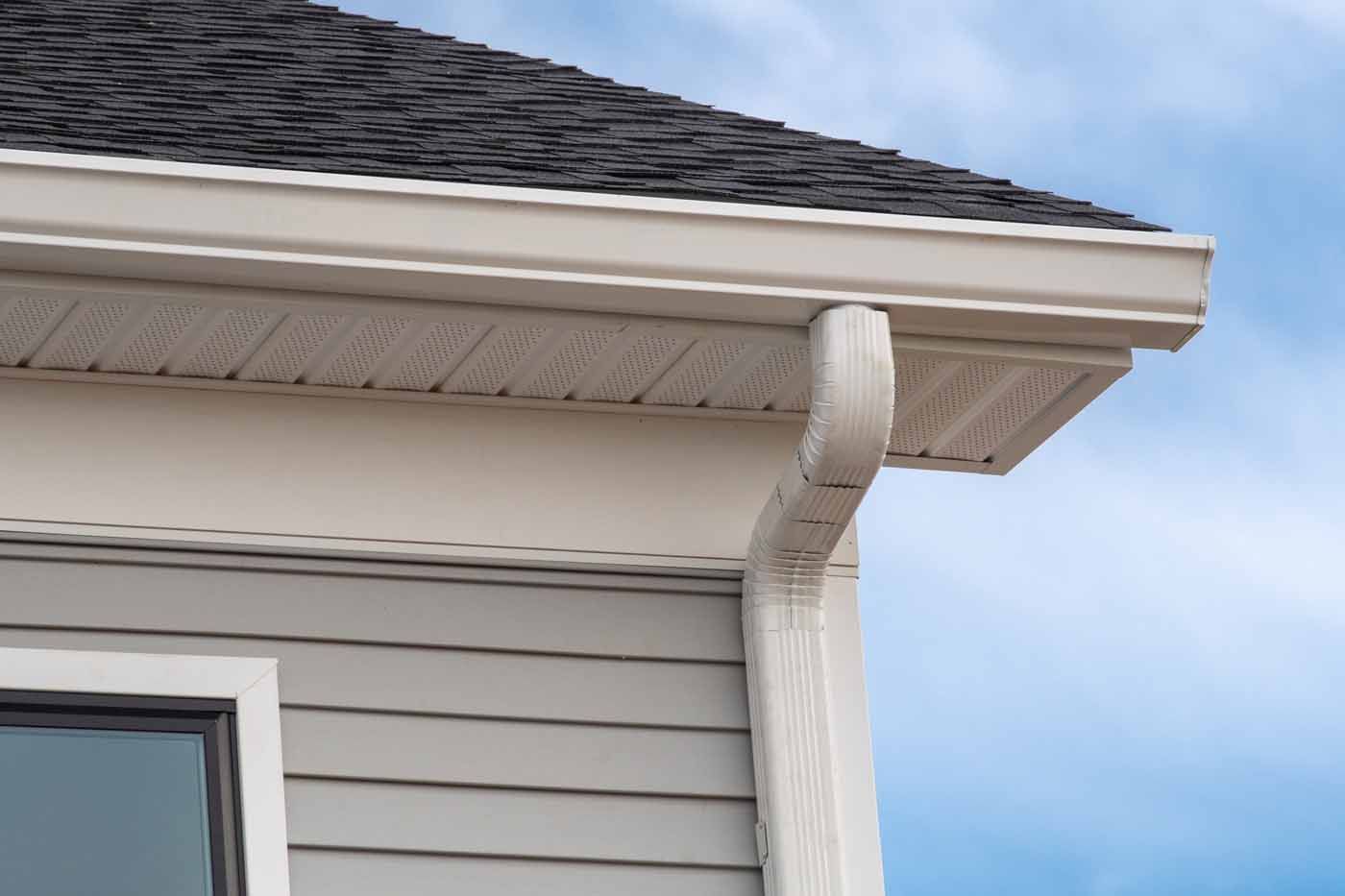 A house with a gutter on the side of it and a window.